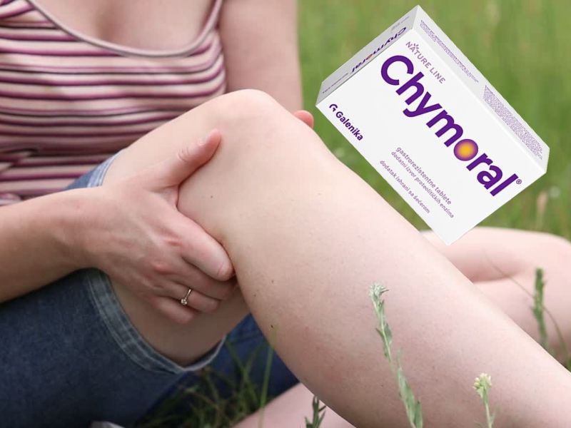 devojka se drži za koleno, sportska povreda, pored nje kutija Chymoral Forte leka