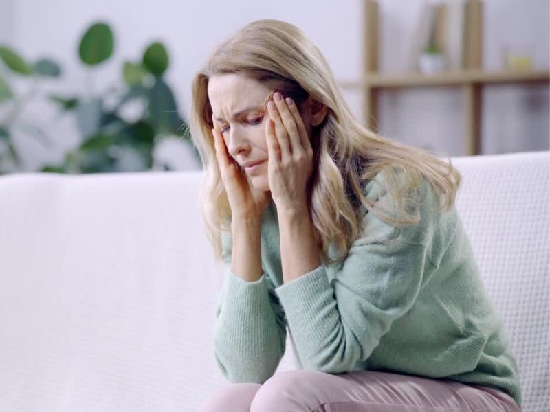 žena srednjih godina se dri za glavu