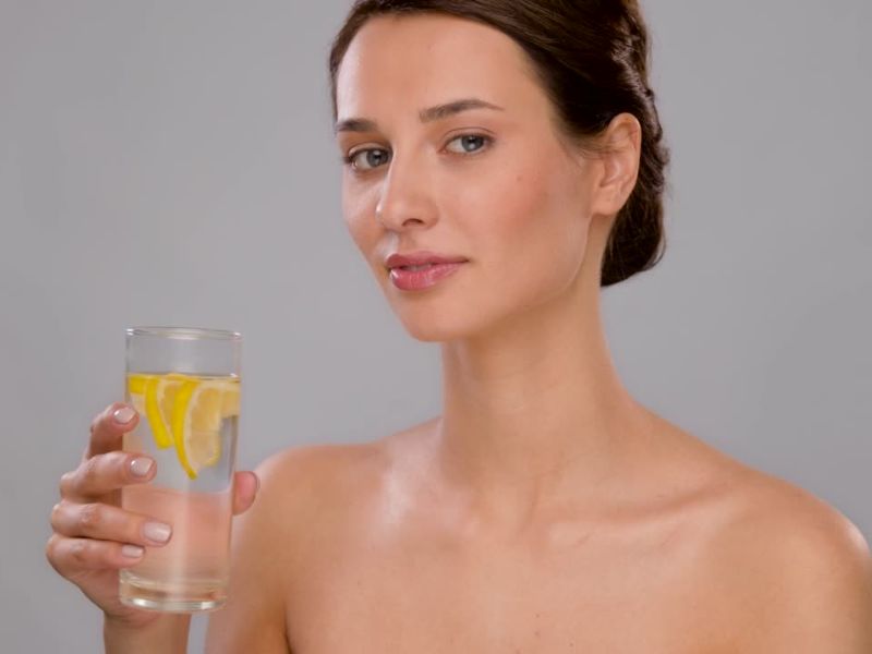 devojka pije toplu vodu sa limunom