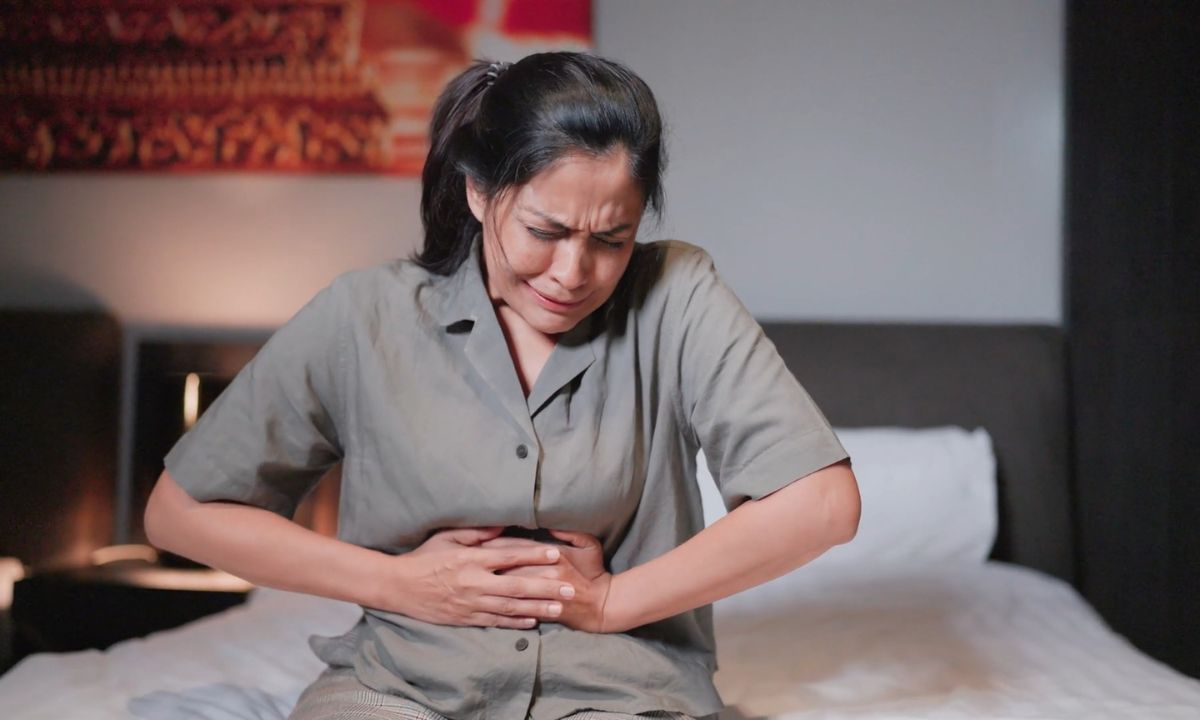 žena se drži za stomak od bola