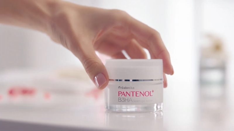 Ruka drži teglicu Pantenol kreme na svetloj površini